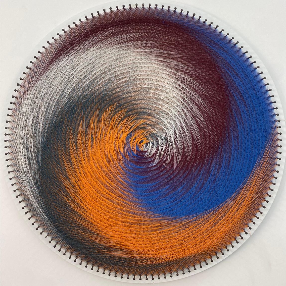 Cosmic Spiral - circular string art in orange, blue and silver thread